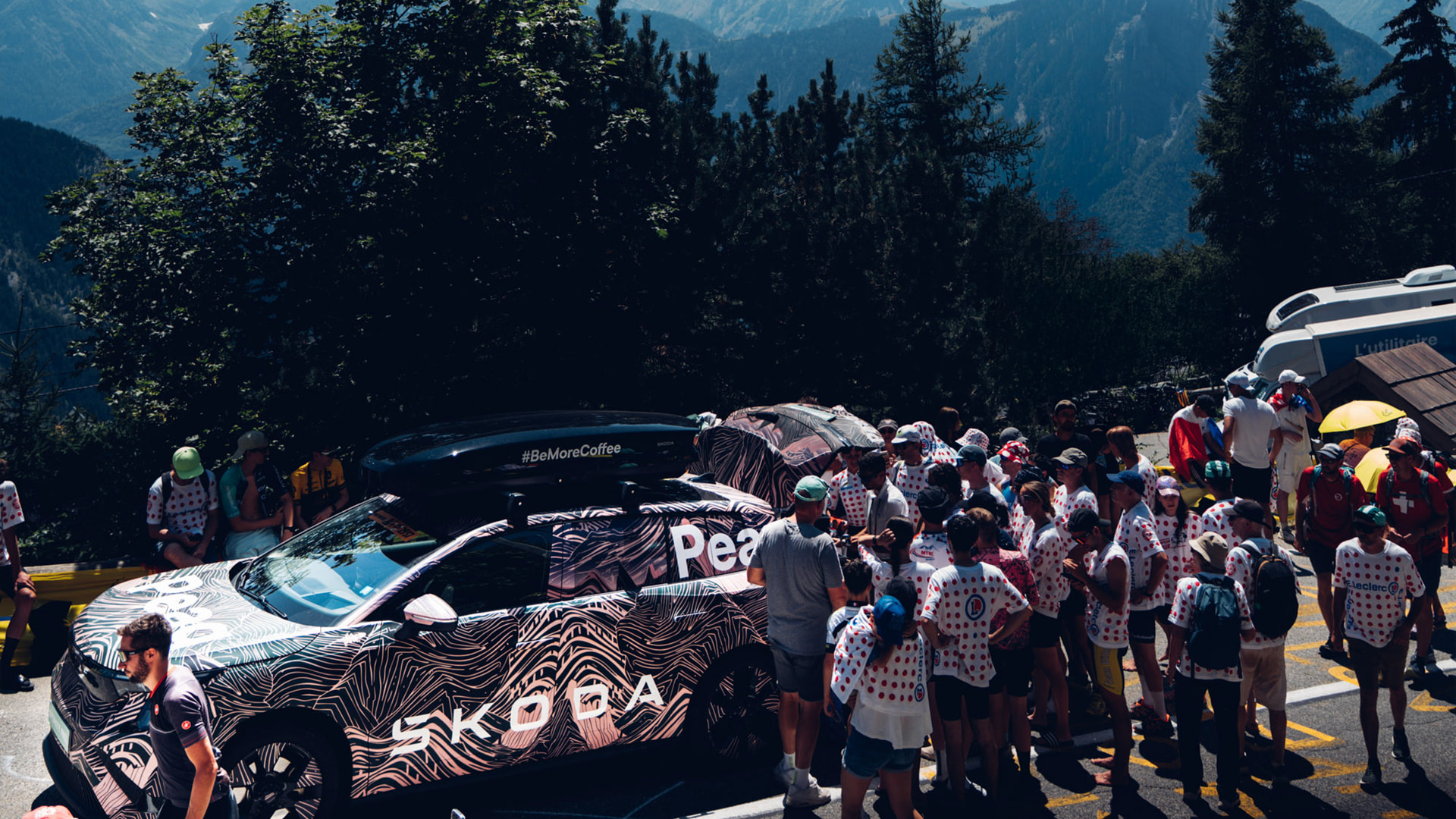 Crowd gathered roadside around the Škoda Peaq on a mountain pass